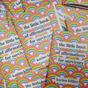 Multiple rainbow print copies of the Zine, the little book of affirmations for survivors