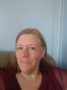 a photo of a white woman without her KF94 facemask smiling in a blue room